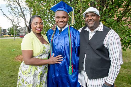 High School graduate with his parents 
